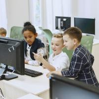 Children in a classroom looking at a computer